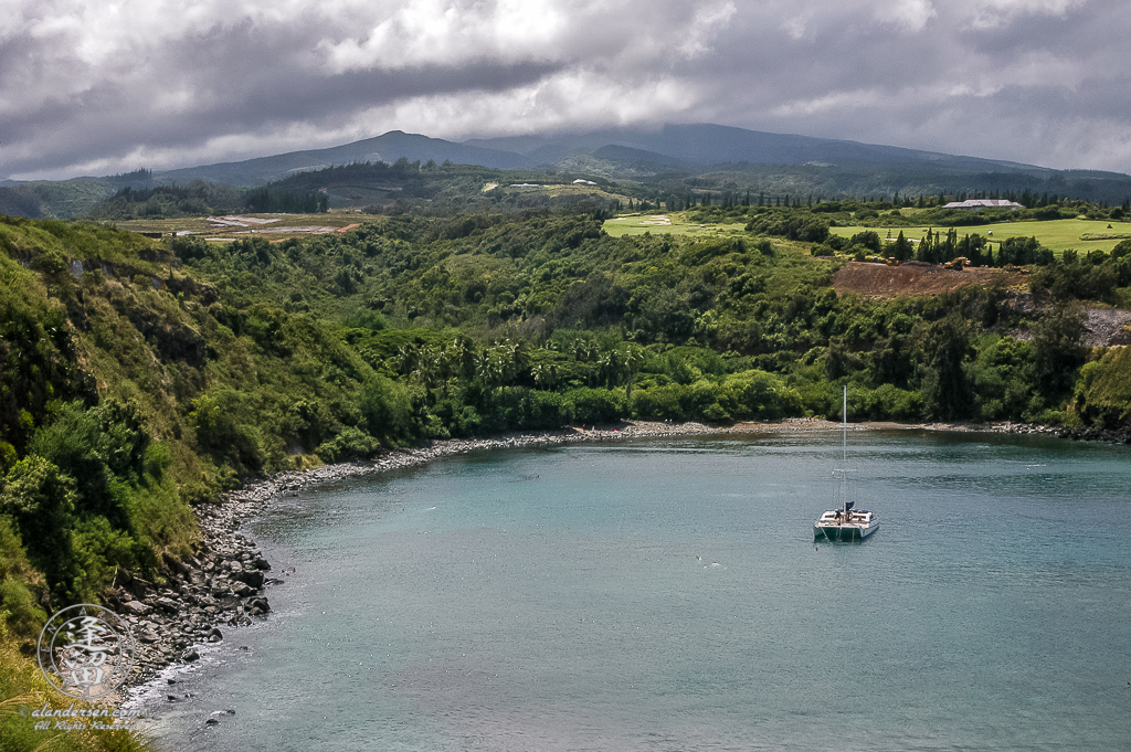 Catamaran anchored in the clear blue waters of Honolua Bay on Hawaiian Island of Maui.