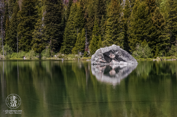 Boulder and tree reflections in String Lake at Grand Teton National Park in Wyoming.