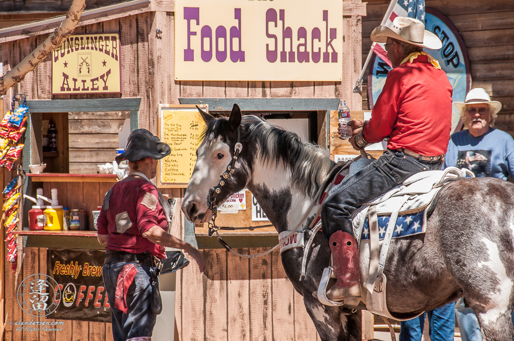 Brightly dressed cowboy on a gray and white spotted horse.