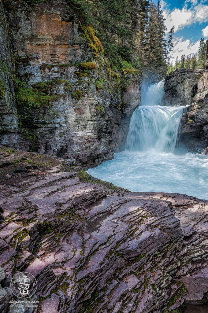 Clear turquoise waters of St. Mary's Falls roaring through a gorge.