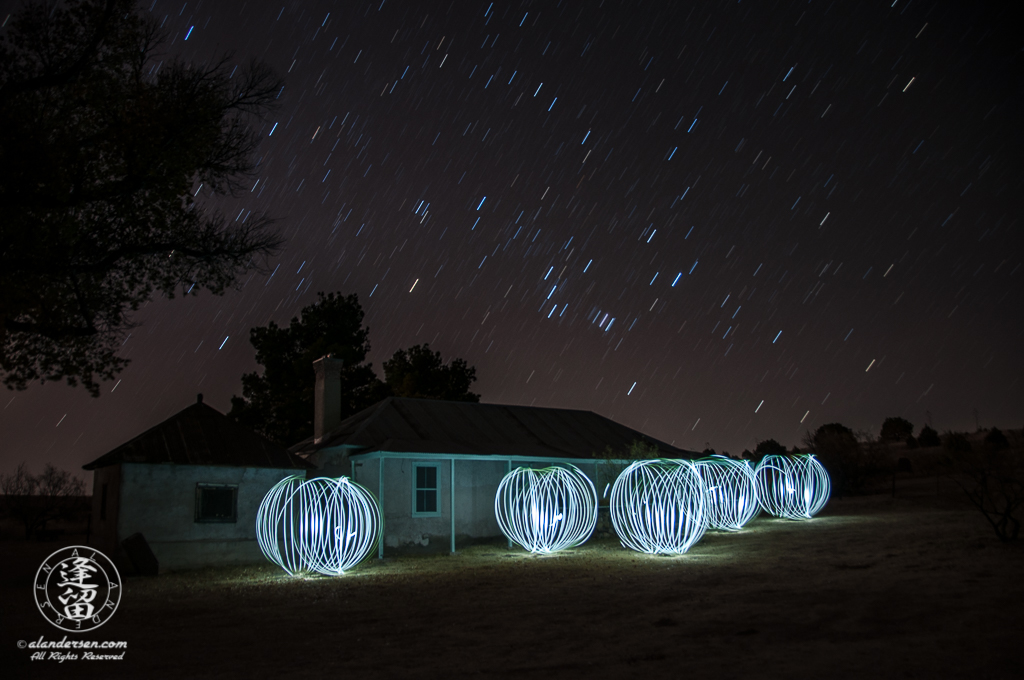 Orion rising over Brown Canyon Ranch House with floating spheres of light.