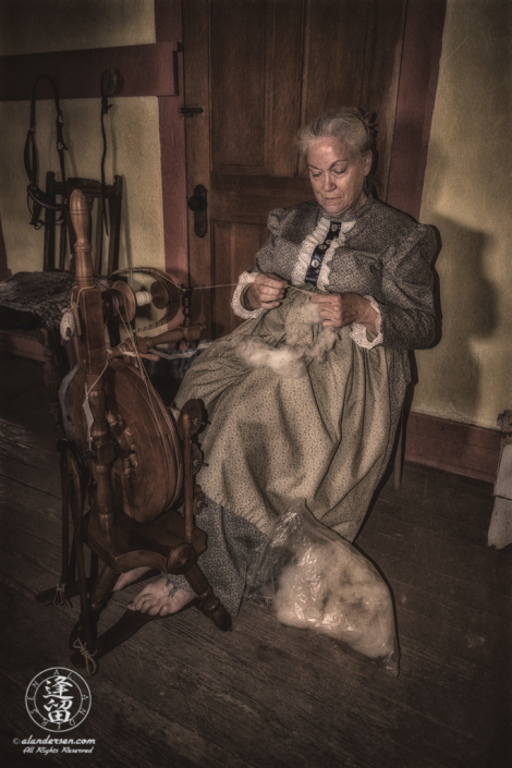 Woman spinning wool in historical dress.