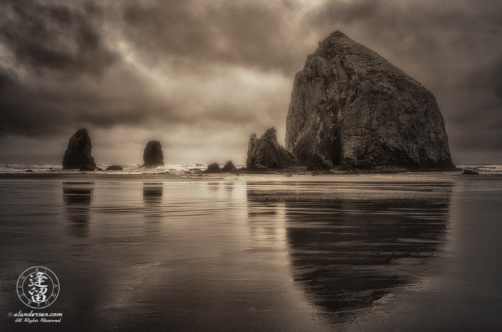 Haystack Rock And The Needles reflected in the wet sand at Oregon's Cannon.