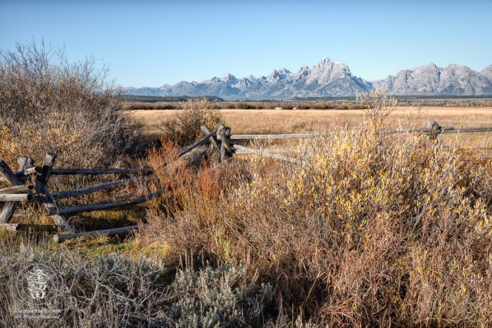 View of Grand Tetons behind the split-rail fence at Cunningham Cabin in Wyoming's Grand Teton National Park.