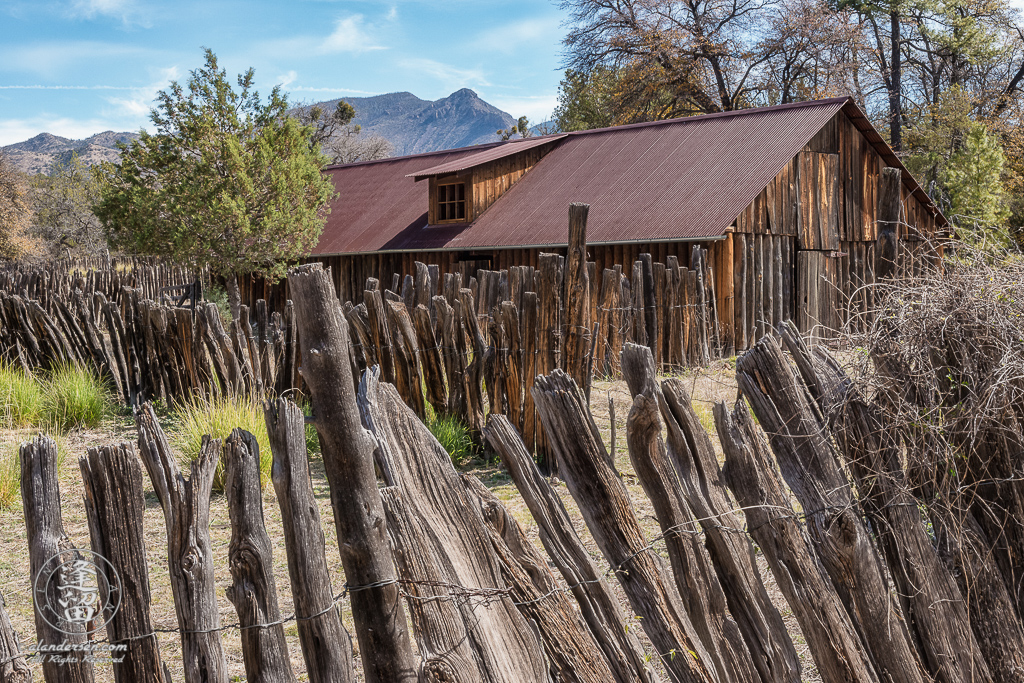 Closeup stockaded barn surrounded by wire-woven log fence at historic Camp Rucker.