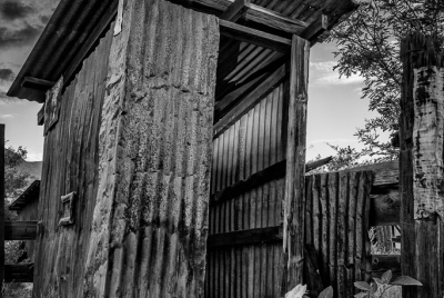 Brown Canyon Ranch Outhouse 5 BW Leaning outhouse made of corrugated tin by Brown Canyon Ranch corrals outside Sierra Vista in Arizona.