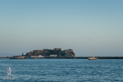 Pelican Rock and Whalers Island Sailboat Kahia lies idle near Whaler Island at Crescent City Bay in Northern California.