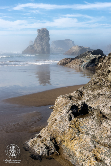 A composition showing various sea stacks at Bandon Beach in Oregon on a misty afternoon.
