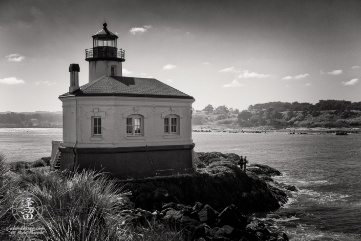 Two men fishing by the Coquille River Lighthouse at the mouth of the Coquille River in Bandon, Oregon.