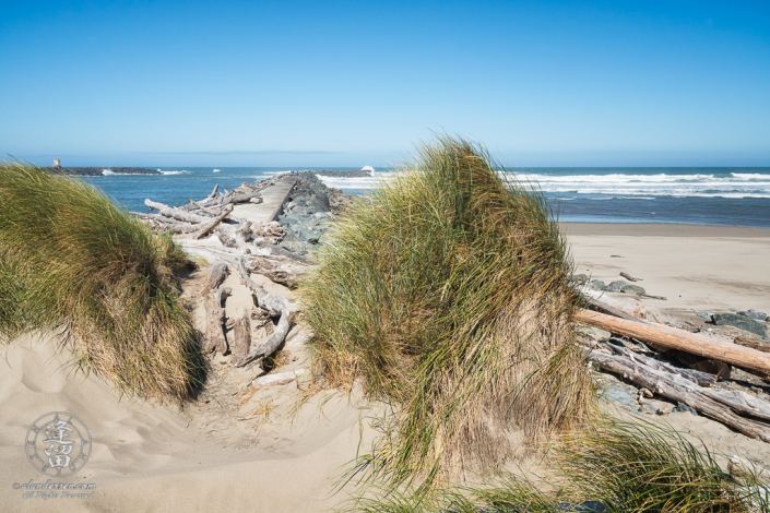 Dunes and grass framing the way out to the North Jetty of the Coquille River at Bandon in Oregon.
