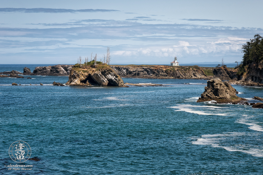 The Cape Arago Lighthouse, as seen from the other side of Sunset Bay on the Pacific Coast Trail to Shore Acres.