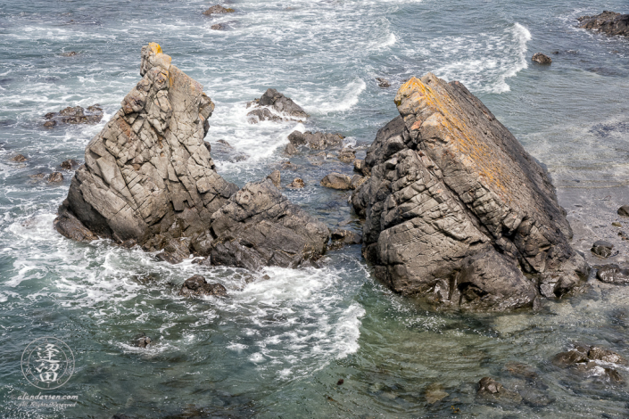 Looking down at the surf breaking on a prominent basalt rock formation from a cliff at Point St George at Crescent City in Northern California.