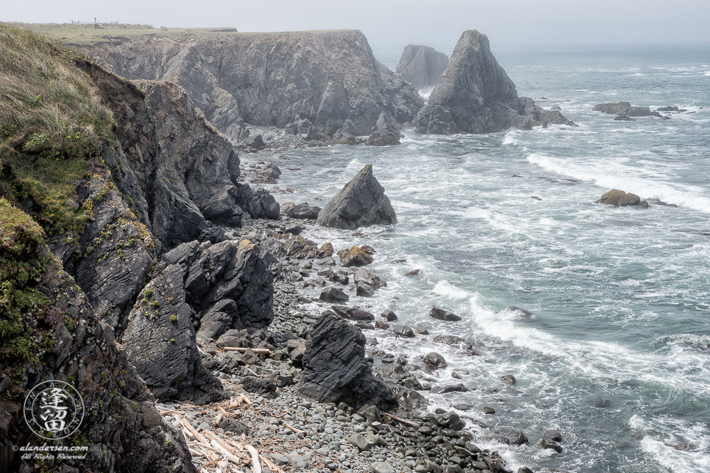 The morning fog is just starting to lift from the cliffs on a beautiful June morning at Kellog Beach, by Point St. George outside of the Northern California town of Crescent City.