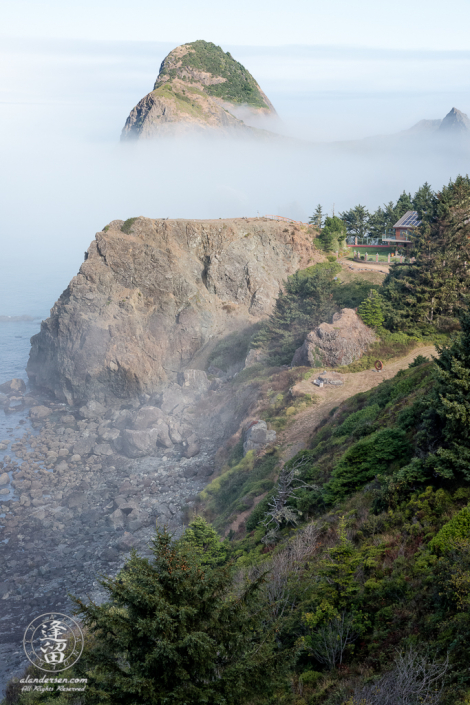Seastacks floating in morning fog provide a fairy-tale ocean view of a cliff-side home on the Southern Oregon Coast near Ophir.