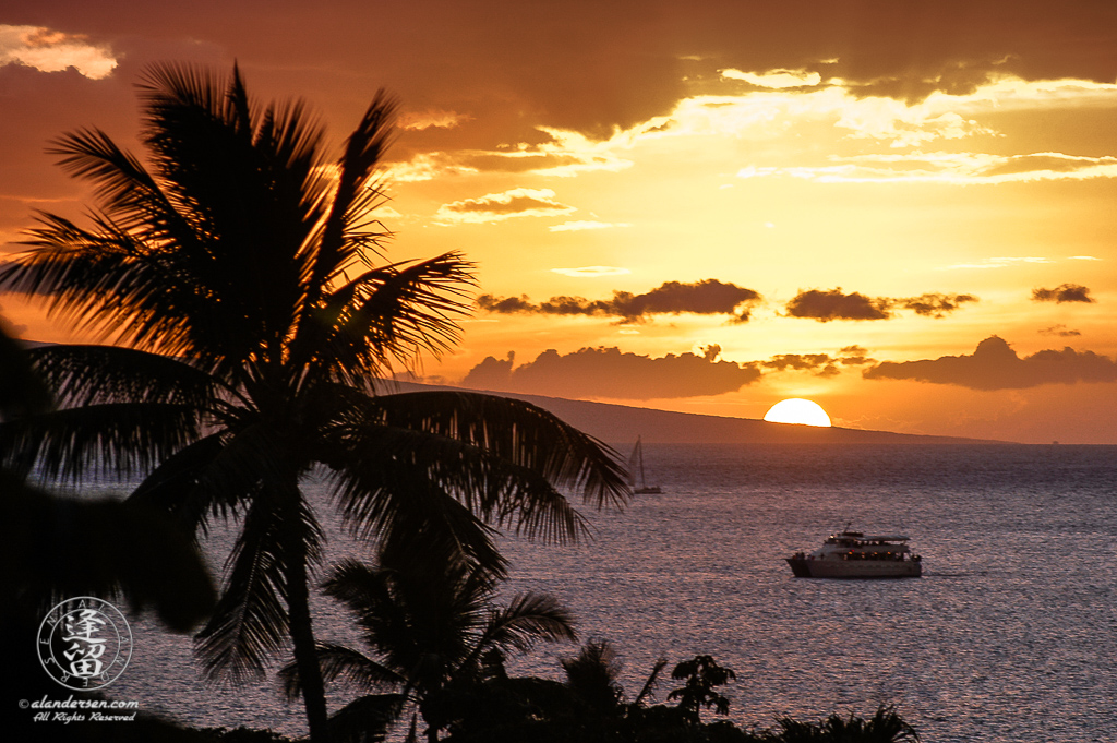 Dinner cruise ship on purple ocean at sunset.