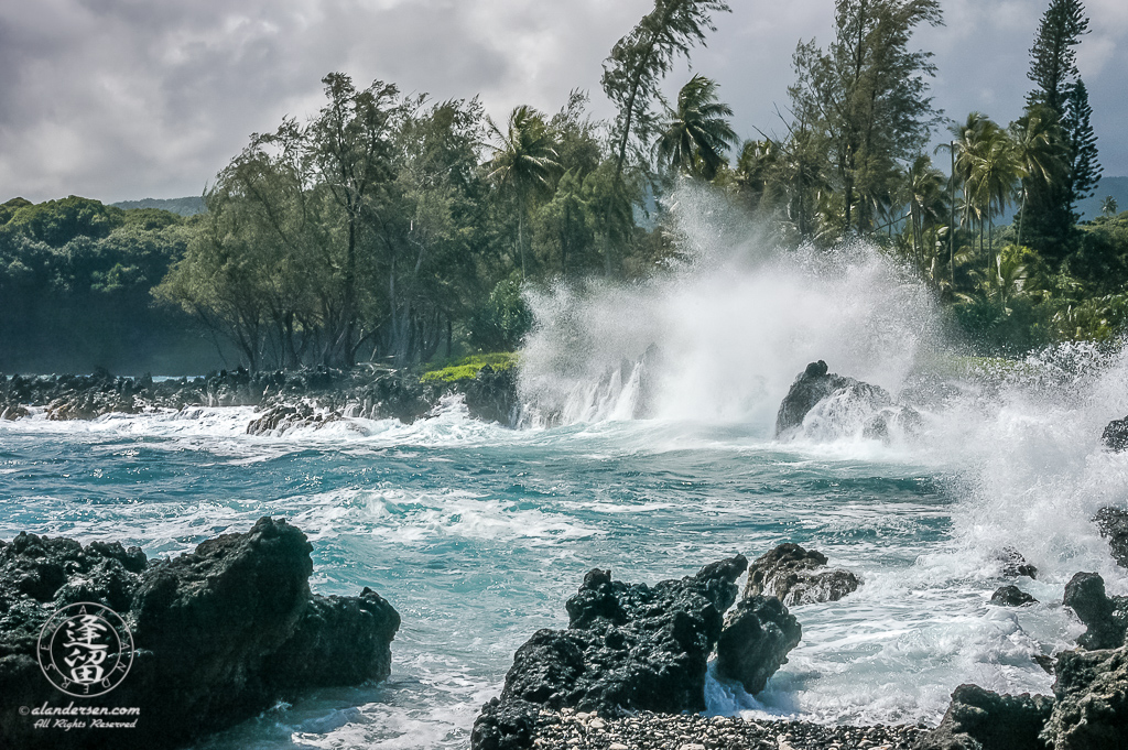 Waves crashing against black lava rocks at Ke‘anae Peninsula.