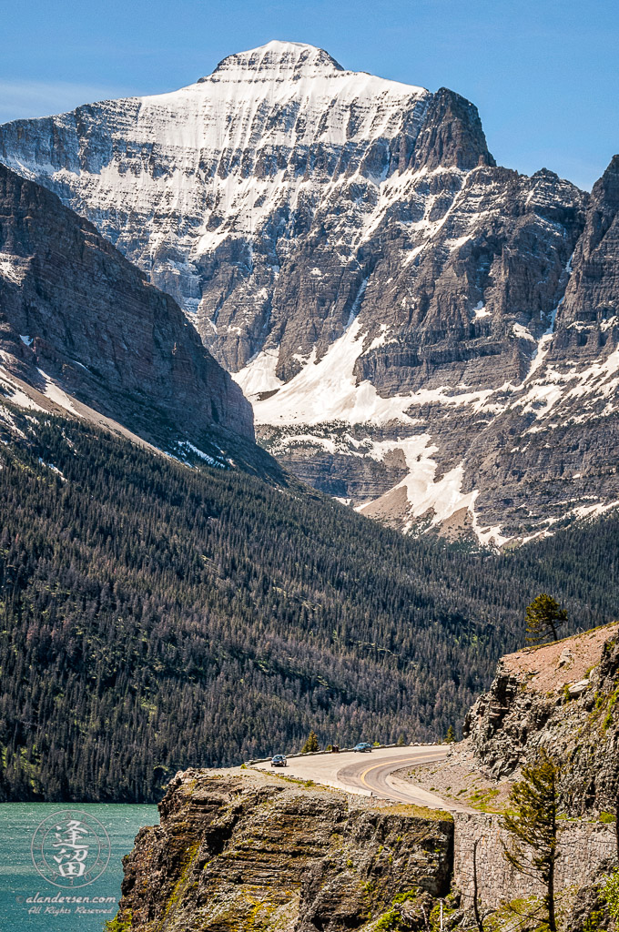 Going To The Sun Road curving around cliff before towering Little Chief mountain.