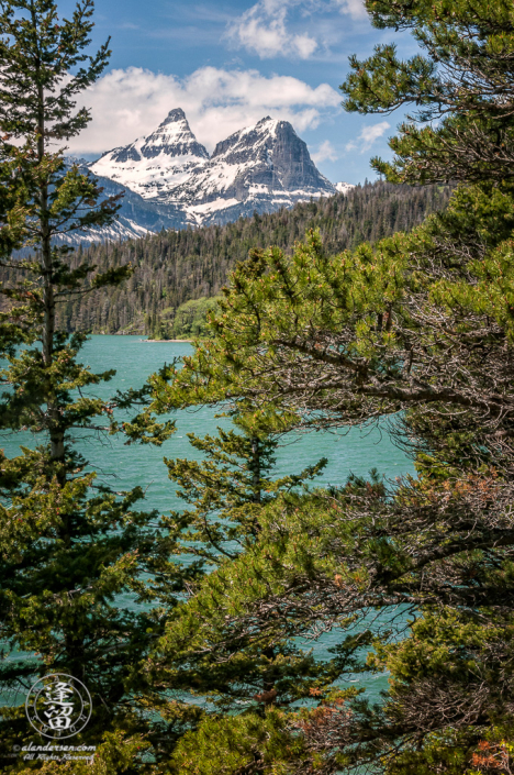 Reynolds Mountain and Heavy Runner framed by pine trees and Lake St Mary's.