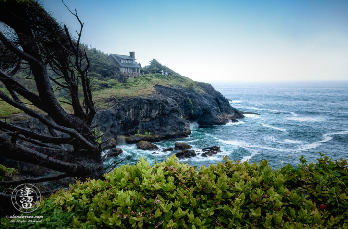 House atop cliffs at Otter Crest Loop during stormy day.