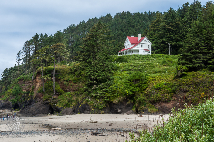 Red-roofed white two-story home of the Hecata Head lighthouse keeper.