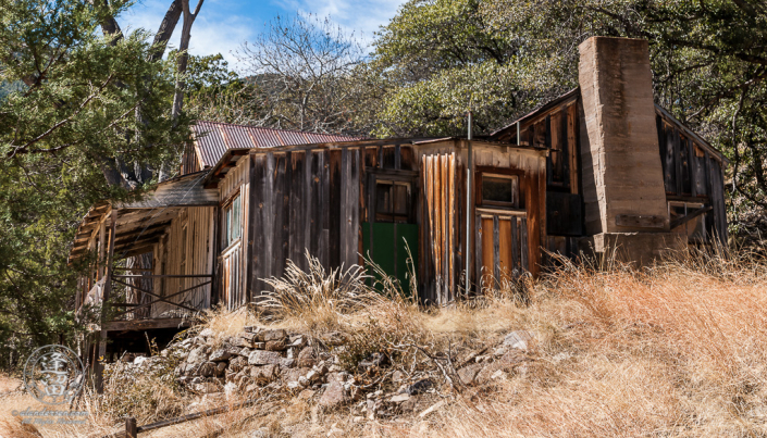 Abandoned homestead built on the side of a hill.