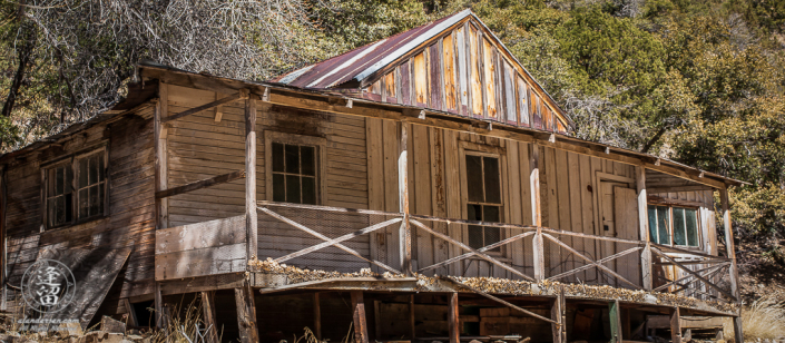 Abandoned homestead built on the side of a hill.