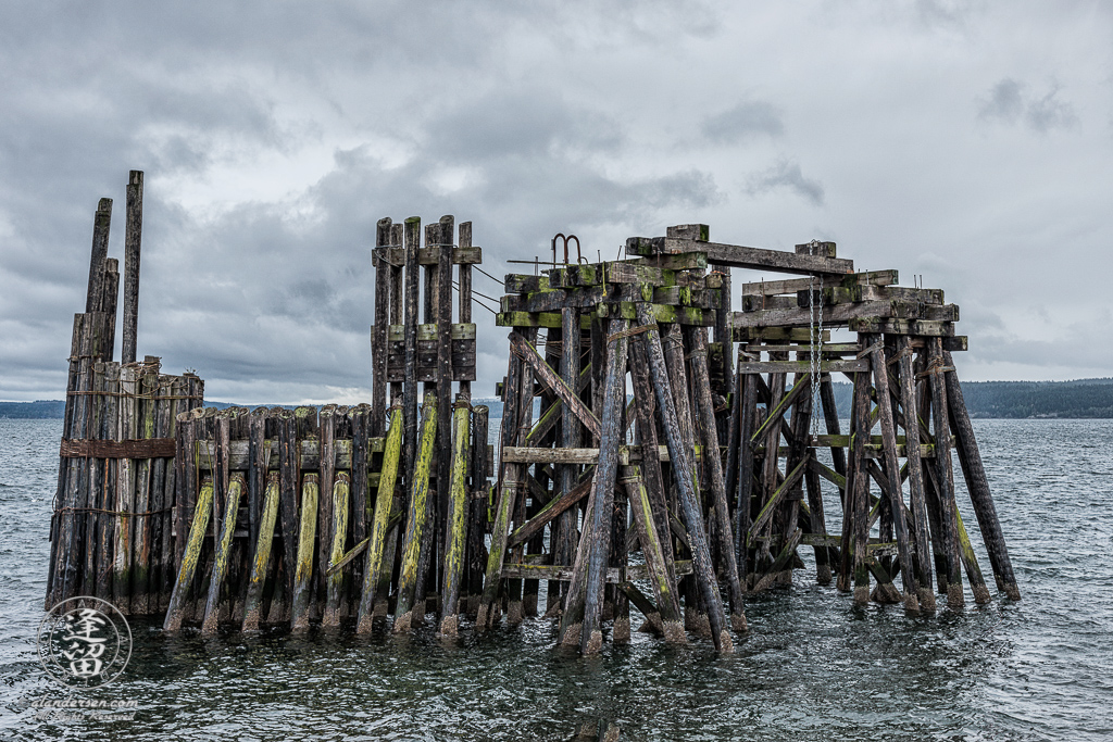 Old wooden ferry dock just off shore in historic downtown Port Townsend, Washington.