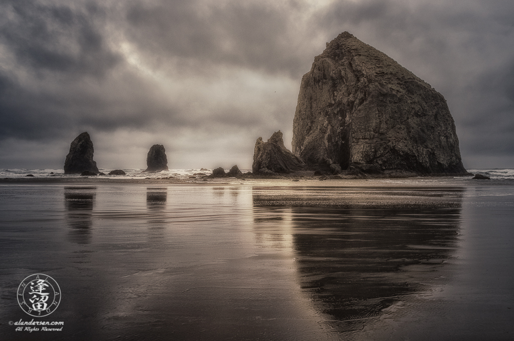 Haystack Rock And The Needles reflected in the wet sand at Oregon's Cannon.