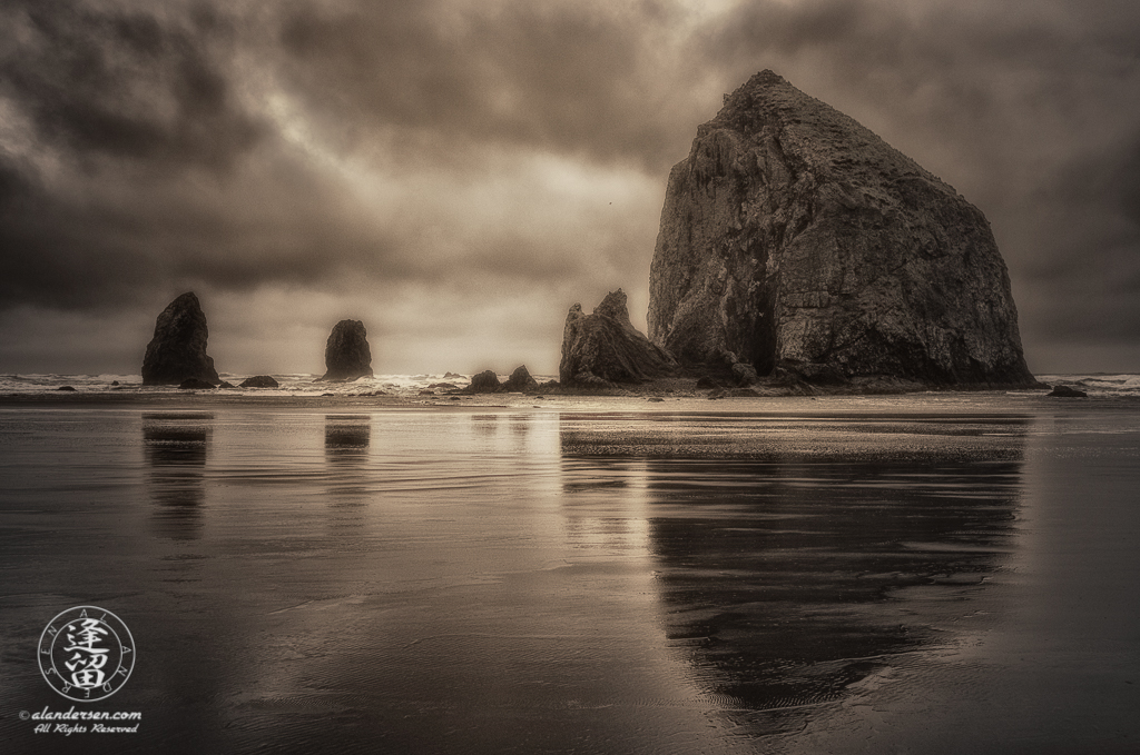 Haystack Rock And The Needles reflected in the wet sand at Oregon's Cannon.