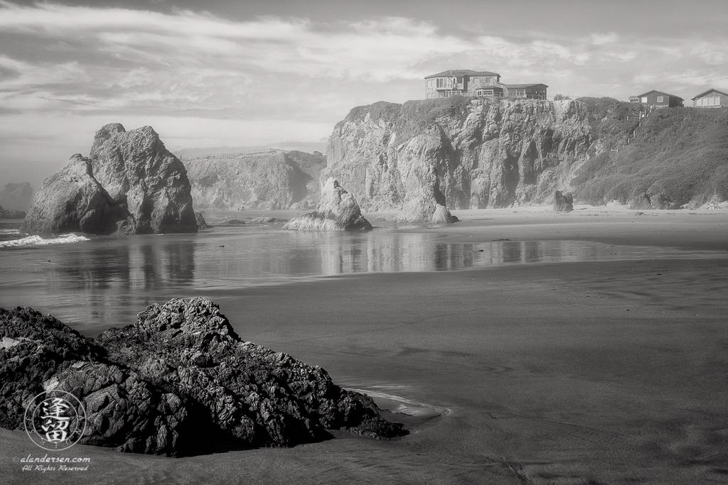 House atop cliffs, seen through the afternoon mists from the beach near Face Rock State Scenic Viewpoint in Bandon, Oregon.