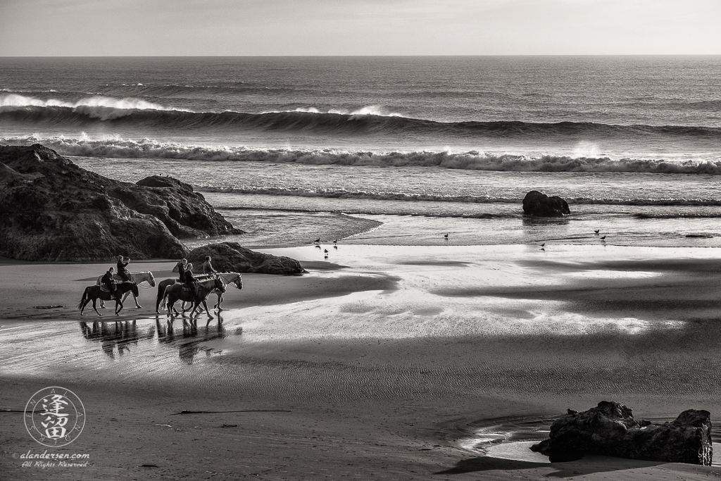 Local horseback riders out enjoying the sunset on Bandon Beach in Oregon.