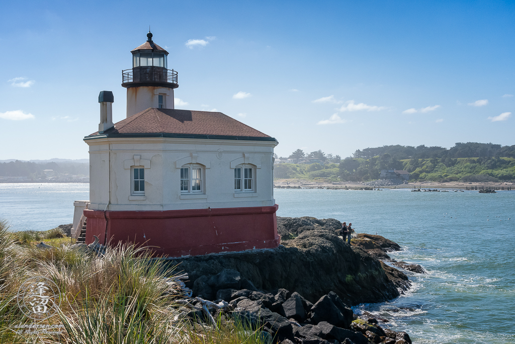 Two men fishing by the Coquille River Lighthouse at the mouth of the Coquille River in Bandon, Oregon.