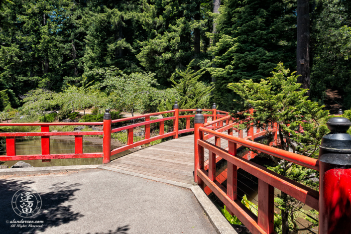 Red Japanese "Morning Song Bridge across Whispering Waters (creek)" in Choshi Gardens at Mingus Park in Coos Bay, Oregon.